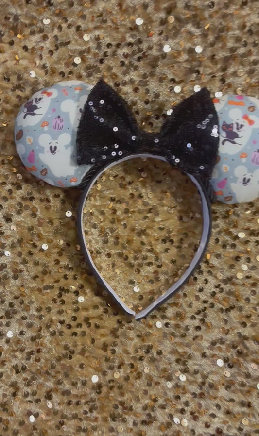 Handmade and ready to ship Halloween Cute Ghosts Mouse ears with the fabric with mouse shaped ghosts on fabric is on the ears, front and back and a black sequin bow. The headband is a universal sized headband and has black poly cotton fabric on it.
