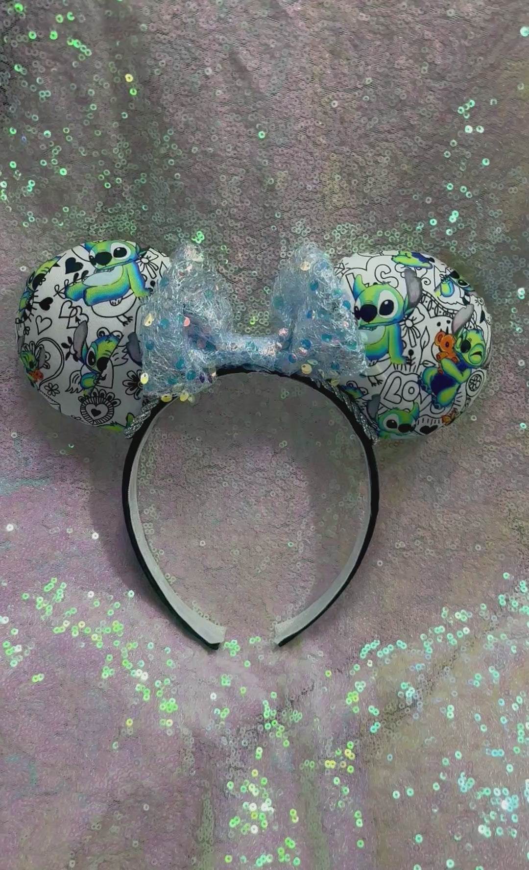 Handmade and ready to ship Mouse ears with Stitch cartoon character design on the fabric with silver twisted trim on a black universal sized headband and a blue sequin bow.