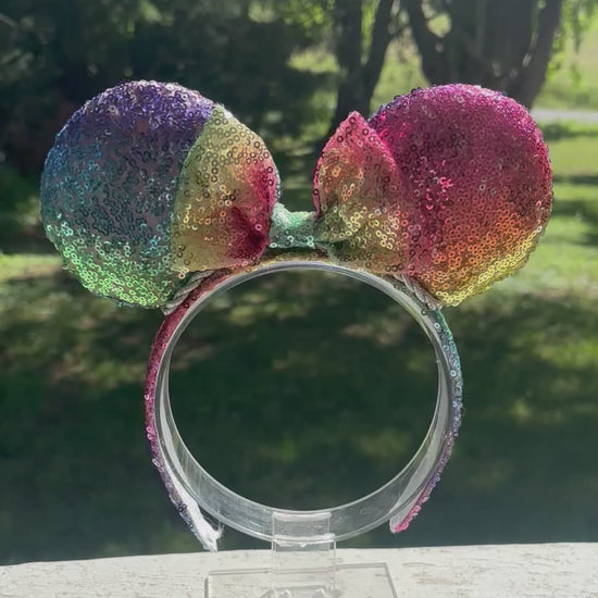Handmade and ready to ship. Mouse ears with rainbow fabric are on the front and back of mouse ears along with the headband with a matching rainbow sequin bow. 