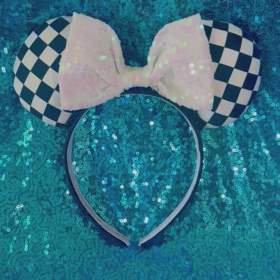 Checkered mouse ears headband with a white sequin bow on a black headband. 