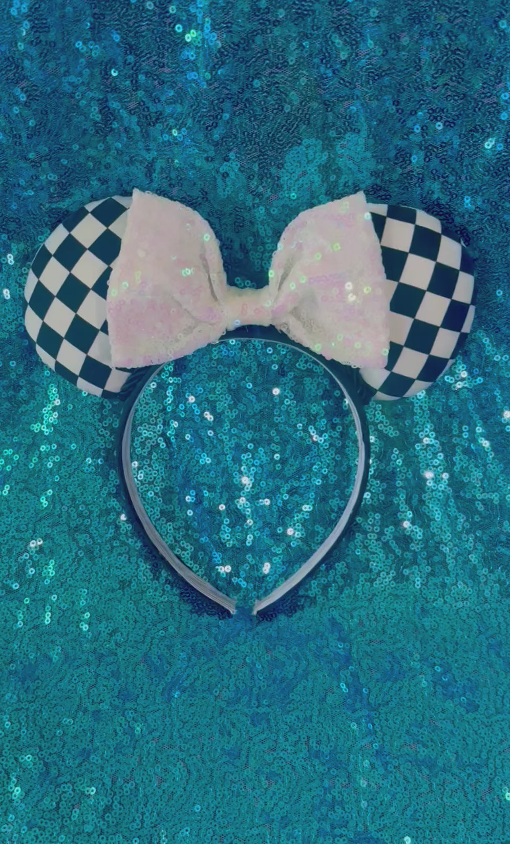 Checkered mouse ears headband with a white sequin bow on a black headband. 