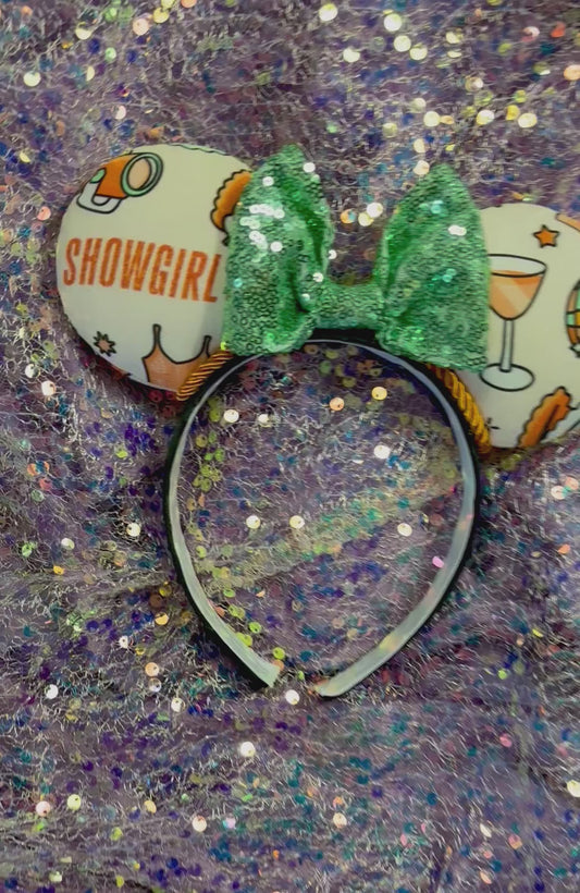 Showgirl themed mouse ears with a mint green sequin bow on a black headband.