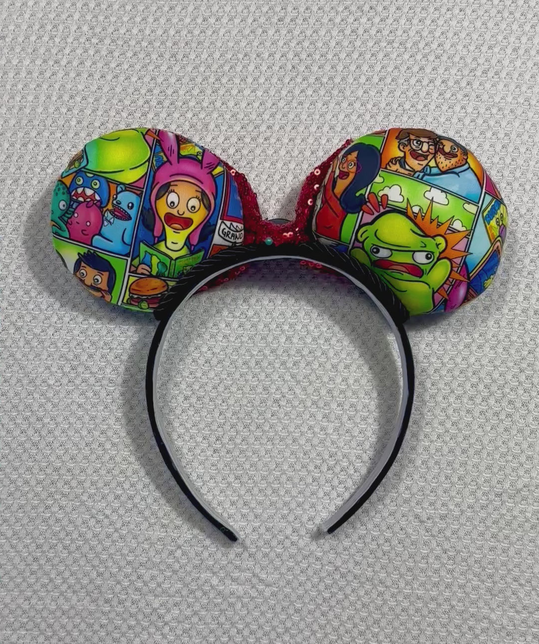 Back of mouse ears. Handmade and ready to ship Belcher and friends mouse ears with the fabric on both the front and back. The headband is black universal sized and fits most. The set has a red sequin bow with a burger embellishment on the middle. Item is shown on a white background.