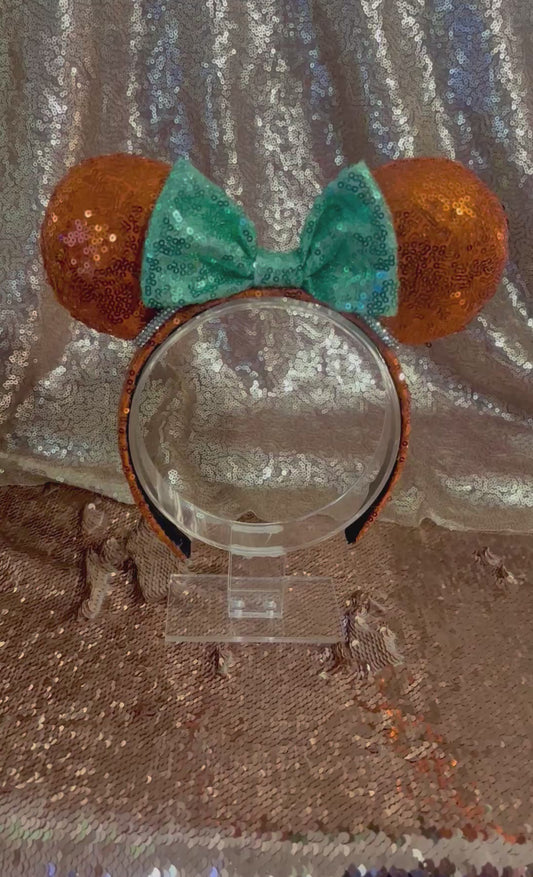 For the Showgirls! Orange Sequin Mouse ears with orange sequin fabric is on the front and back along with on the headband as well that is UNIVERSAL sized with a mint green bow.