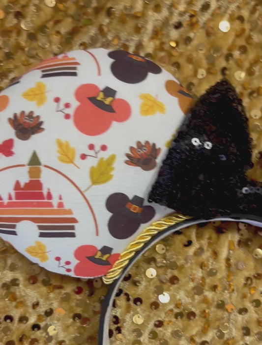 Thanksgiving park themed mouse ears on a black headband with a black sequin bow. 