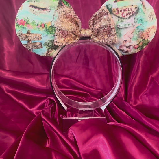 Handmade and ready to ship Jungle Cruise themed mouse ears with images from the attraction on a black headband and shown with a gold bow option.