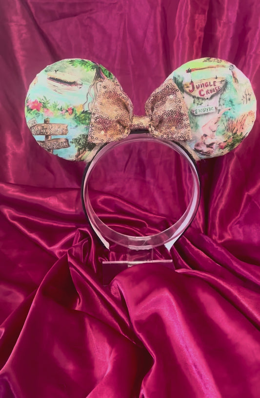 Handmade and ready to ship Jungle Cruise themed mouse ears with images from the attraction on a black headband and shown with a gold bow option.