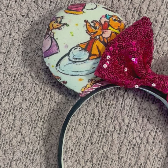Handmade and ready to ship Sewing Mice mouse ears with the fabric on both the front and back. The headband is black universal sized and fits most. The set has a hot pink sequin bow with pink twisted trim along the inner mouse ears. Item is shown on a lavender fluffy background.