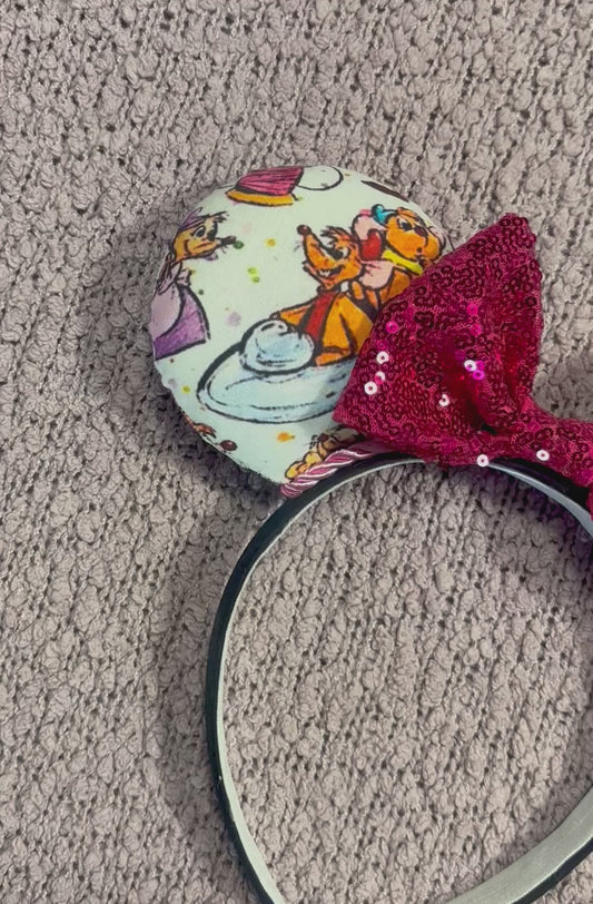 Handmade and ready to ship Sewing Mice mouse ears with the fabric on both the front and back. The headband is black universal sized and fits most. The set has a hot pink sequin bow with pink twisted trim along the inner mouse ears. Item is shown on a lavender fluffy background.