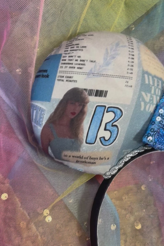Mouse ears with a blue bow and newspaper print on a colorful background