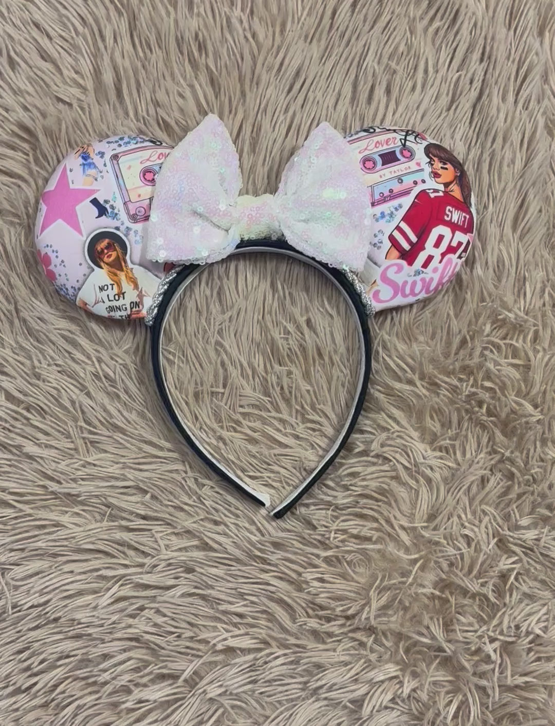 An ear headband with a large iridescent bow and custom printed ears featuring retro cassette graphics, a pink star, and a portrait of singer.