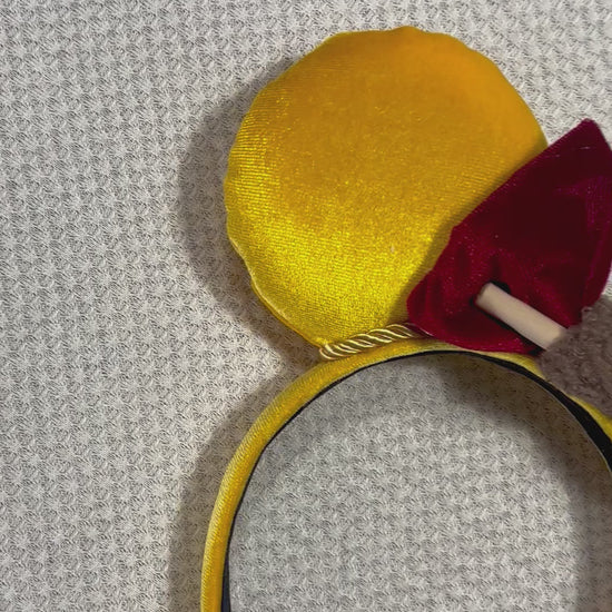 Yellow mouse ears with a red bow with a mini honeycomb and fluffy brown middle