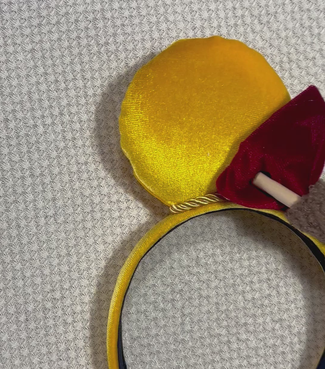 Yellow mouse ears with a red bow with a mini honeycomb and fluffy brown middle