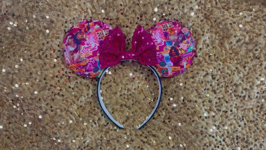 Handmade and ready to ship Colorful Chappell inspired Mouse ears with a hot pink bow on a headband against a gold sequin background.