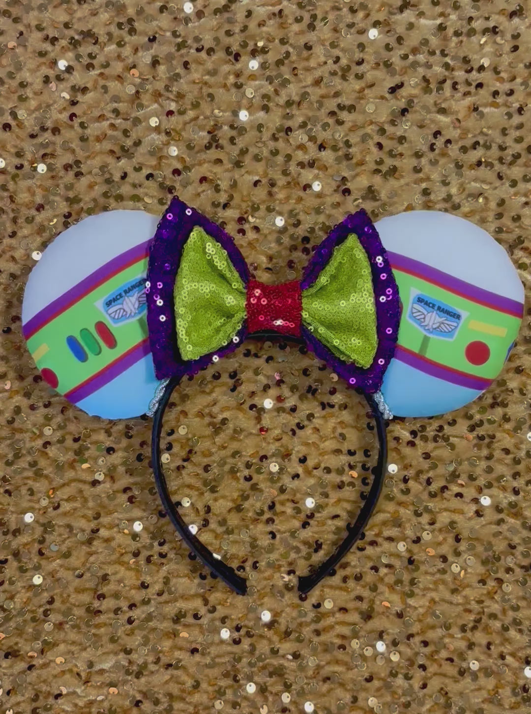 Space Ranger Mouse Ear headband with new improved bow. Handmade and ready to ship with Space ranger fabric on both the front and the back of mouse ears. The set has a silver twisted trim along the inner ears and a new sequin bow that is purple, lime green and red in sequin. Ears are on a black poly cotton universal sized headband.