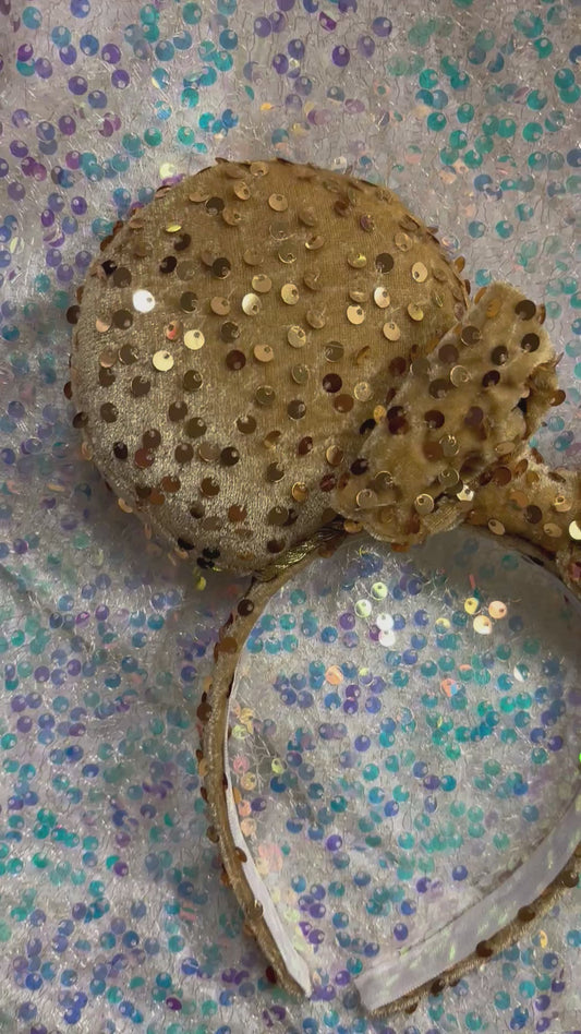Handmade and ready to ship. These are golden velvet sequin mouse ears with a matching bow on a glitter background.