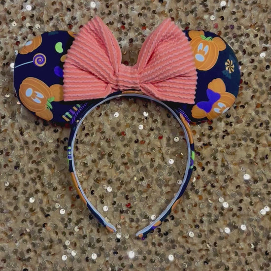 handmade mouse ears with halloween boo to you fabric on ears and the headband.  Orange waffle print bow