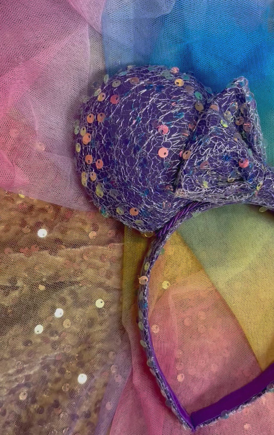 Purple sequin mouse ears on a rainbow background