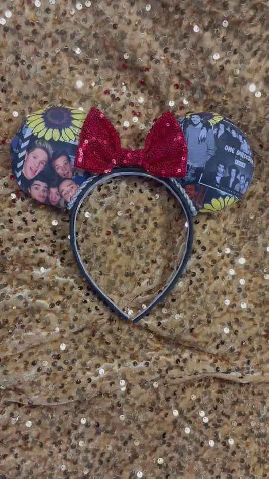 Mouse ear headband featuring boy band with a red sequin bow and floral designs on a glittery gold background.